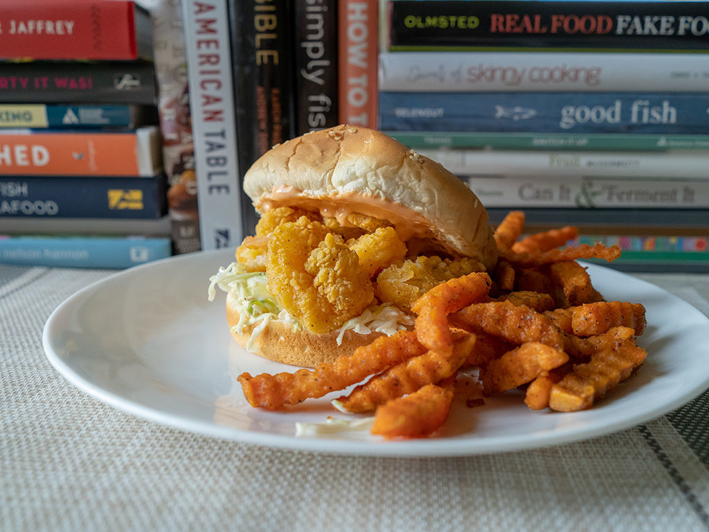 Whole Catch Shrimp Poppers on. bun with sweet potato fries
