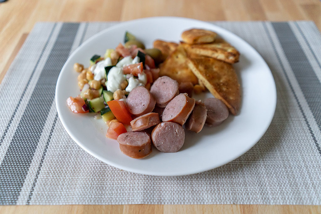 Bovine And Swine garlic knackwurst with salad and pita