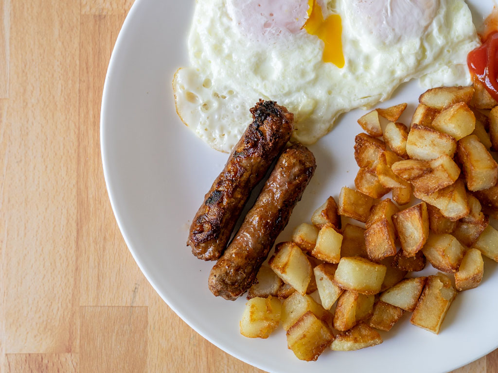 Beyond Breakfast Sausage Links cooked with eggs and breakfast potatoes close up